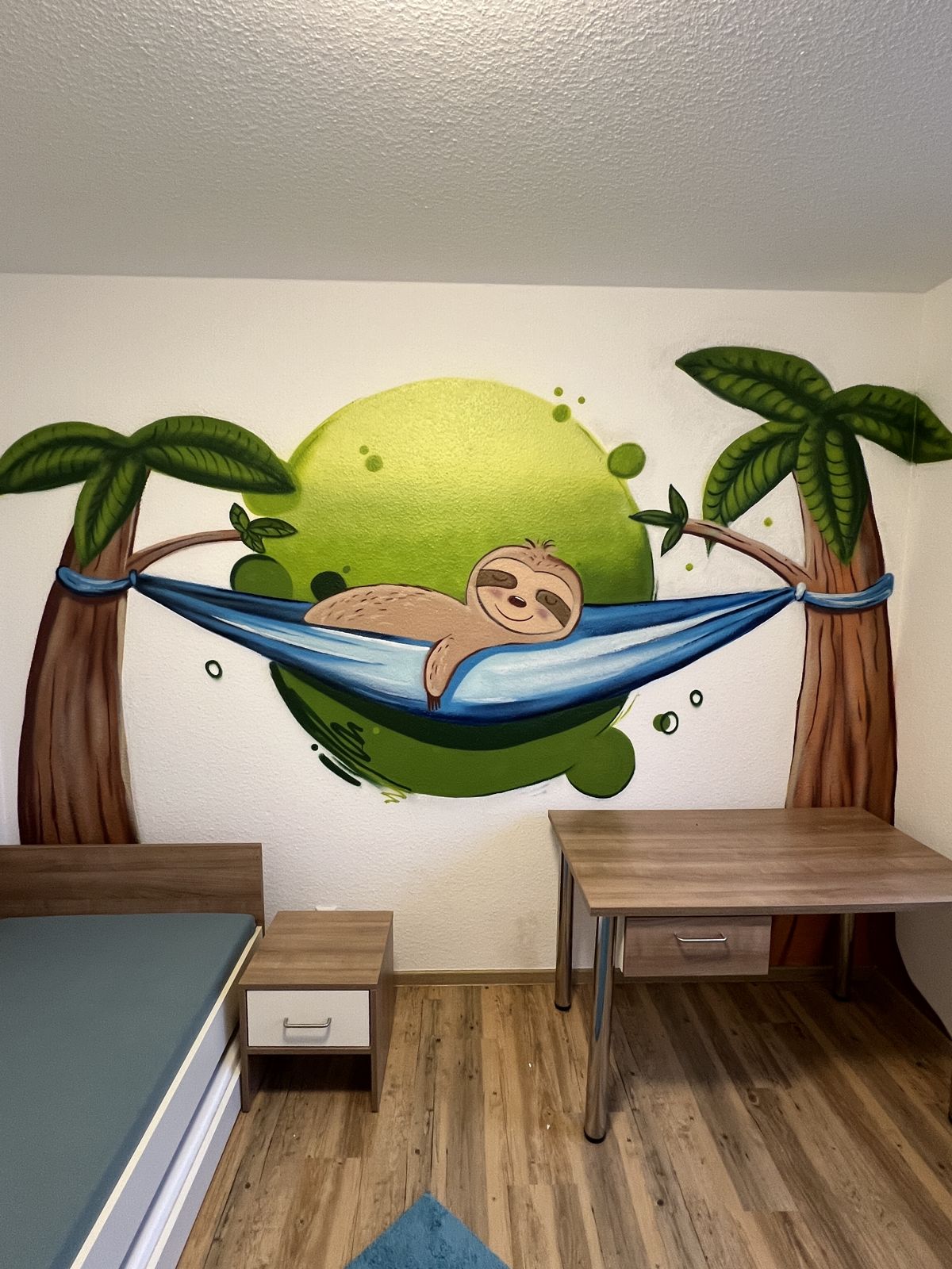 Wandbild in einem Kinderzimmer in Ibbenbüren: Faultier in der Hängematte zwischen Palmen