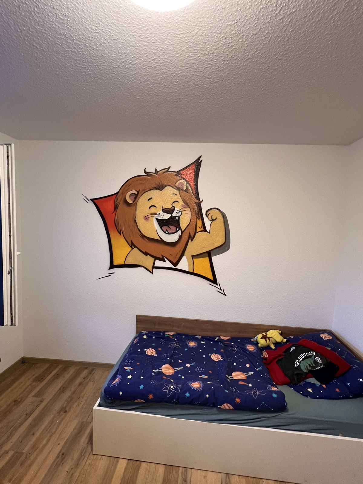 Wandbild in einem Kinderzimmer in Ibbenbüren: lachender Löwe mit Muskelarm